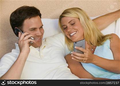 Couple Using Cell Phone and PDA