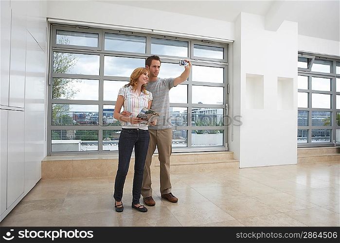 Couple Using Digital Camera in New Apartment