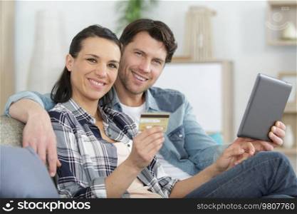 couple using digital tablet and credit card to buy online