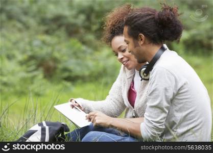 Couple Using Digital Tablet Whilst Hiking In Countryside