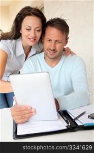 Couple using electronic tablet at home
