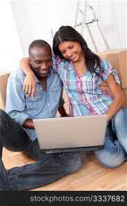 Couple using laptop computer in their new house