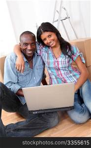 Couple using laptop computer in their new house