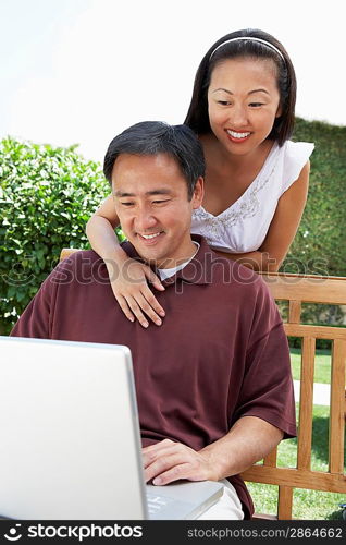 Couple Using Laptop in Garden