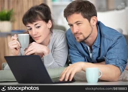 couple using laptop on desk at home