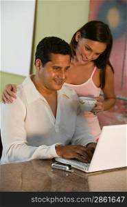 Couple Using Laptop on Kitchen Counter