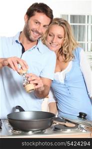 Couple using peppper grinder