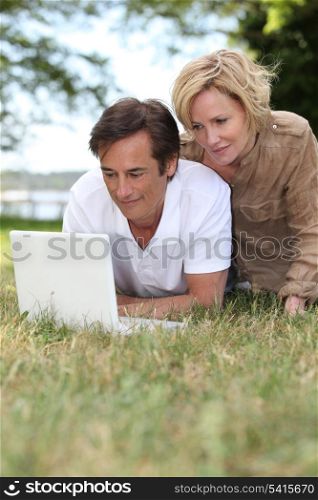 Couple using their laptop in a public park