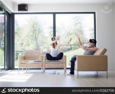Couple using virtual reality headset in living room at home people playing game with new trends technology