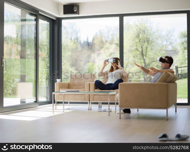 Couple using virtual reality headset in living room at home people playing game with new trends technology