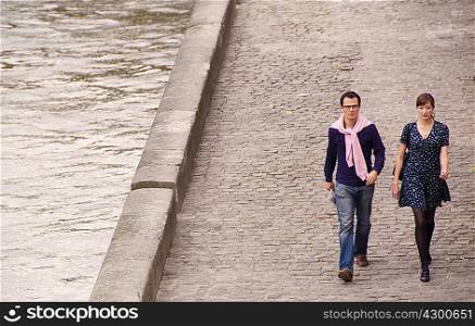 Couple walk beside the Seine Paris