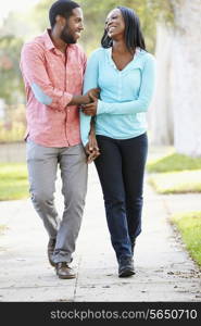 Couple Walking Along Suburban Street Together