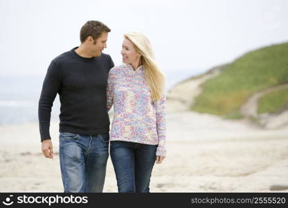 Couple walking at beach smiling