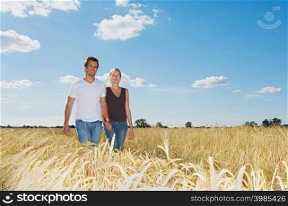 Couple walking in a field of wheat