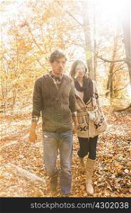 Couple walking in forest holding hands