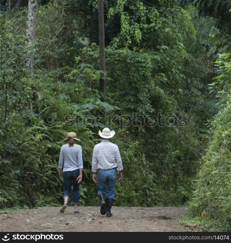 Couple walking on a pathway in forest, Finca El Cisne, Honduras