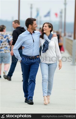 couple walking on a pier on a seaside when traveling