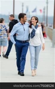 couple walking on a pier on a seaside when traveling