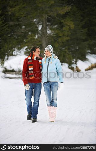 Couple walking on snow-covered path