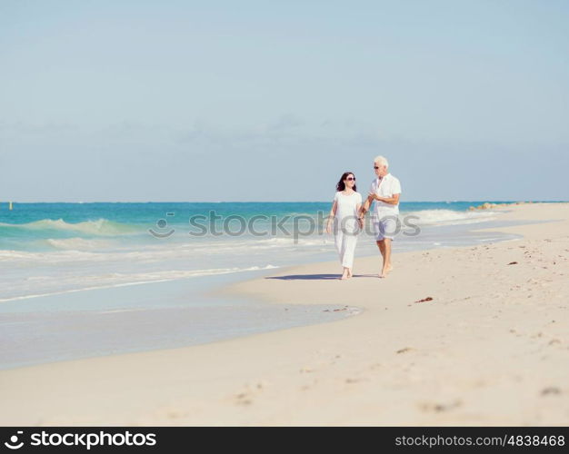 Couple walking on the beach. Walk along the waves