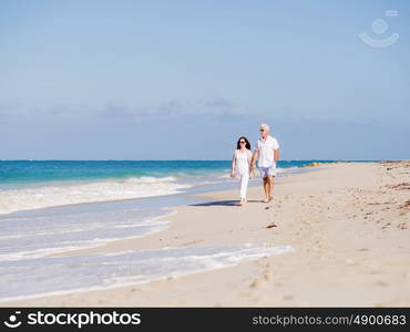 Couple walking on the beach. Walk along the waves