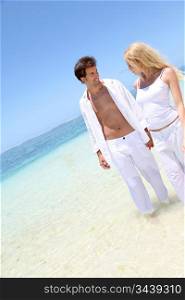 Couple walking on white sandy beach
