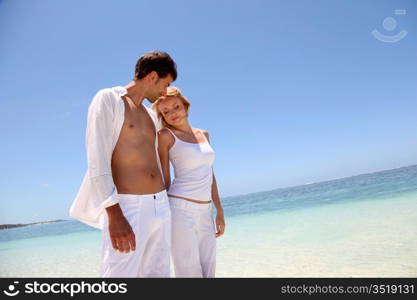 Couple walking on white sandy beach