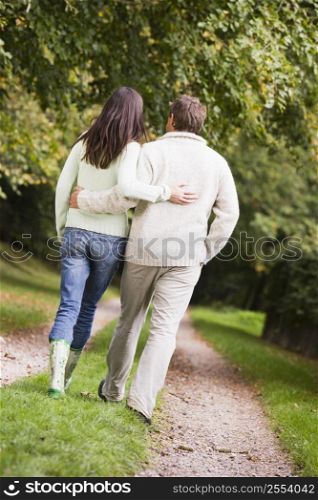 Couple walking outdoors on path in park (selective focus)