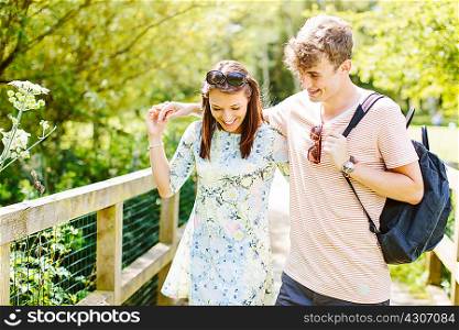 Couple walking over wooden bridge in the park
