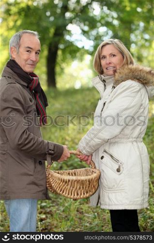 Couple walking through field with basket