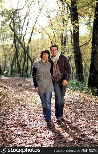 Couple walking through park in autumn