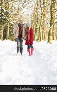 Couple Walking Through Snowy Woodland