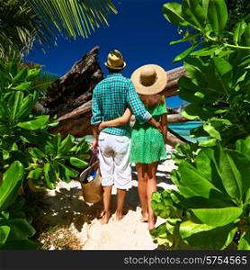 Couple walking to the beach Anse Source d&rsquo;Argent among tropical foliage at Seychelles, La Digue.