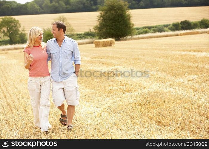 Couple Walking Together Through Summer Harvested Field