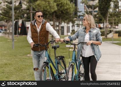 couple walking with bike them outside
