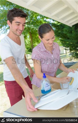 Couple washing dishes on campsite