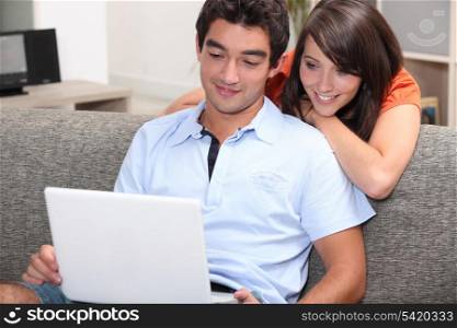 Couple watching film on laptop computer at home