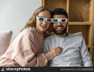 couple watching movie home with three dimensional glasses