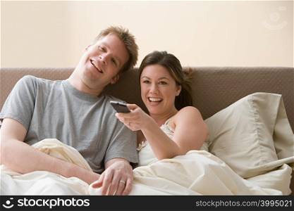 Couple watching television in bed