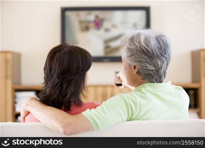 Couple watching television using remote control