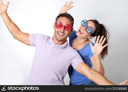 Couple wearing colored glasses having fun on white background