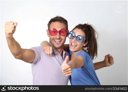 Couple wearing colored glasses having fun on white background