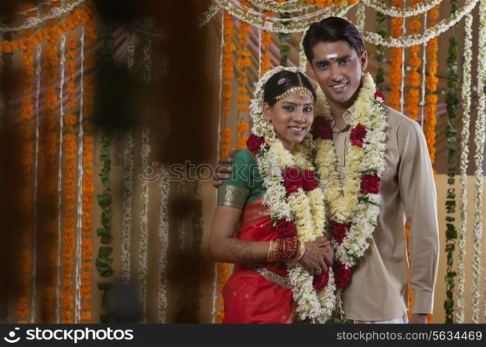 Couple wearing garlands during traditional Indian wedding