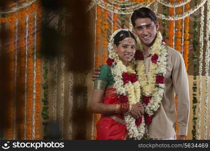 Couple wearing garlands during traditional Indian wedding