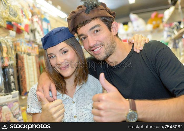 Couple wearing hats in fancy dress shop