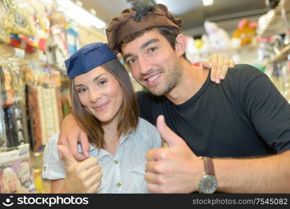 Couple wearing hats in fancy dress shop