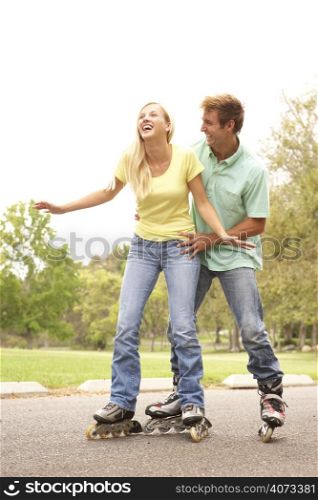 Couple Wearing In Line Skates In Park