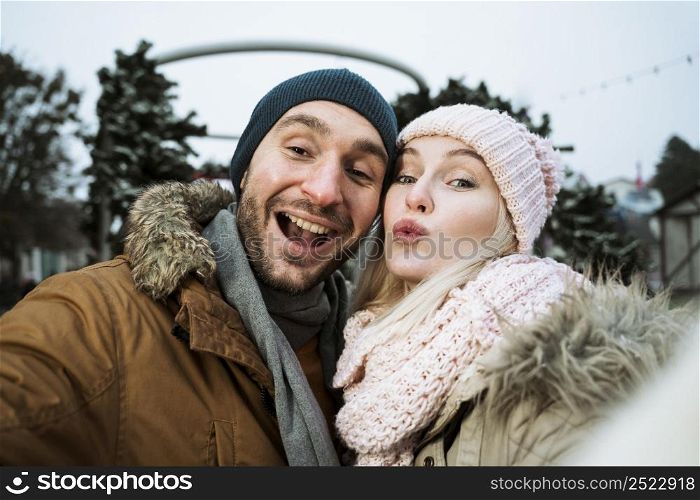 couple winter blowing kiss