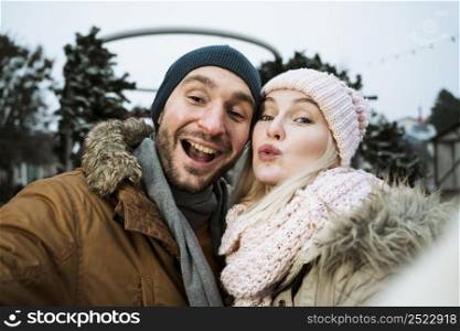 couple winter blowing kiss