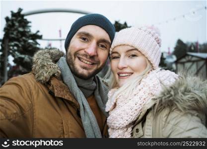 couple winter smiling camera